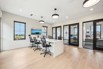 A conference room with a long table and chairs.